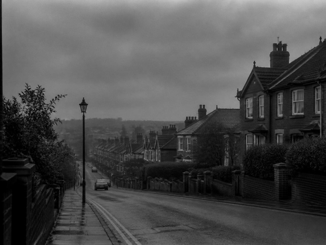 Quiet English town street in the rain, representing Louie Henderson's beginnings in Milton Keynes